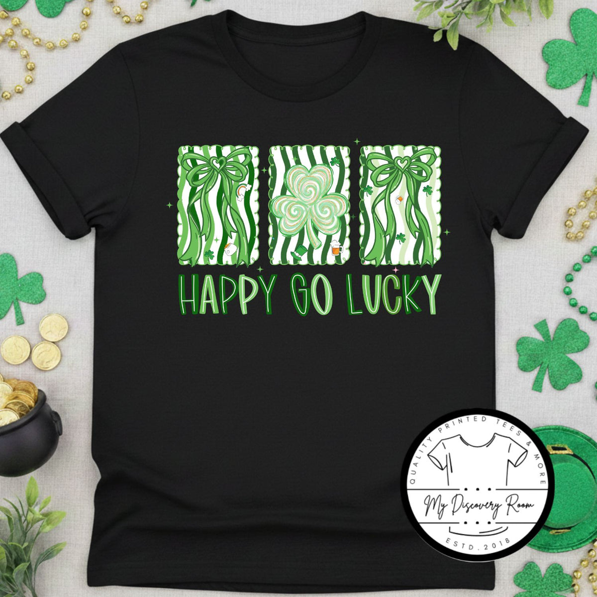 Black t-shirt with green graphics and 'Happy Go Lucky' text on a festive background.