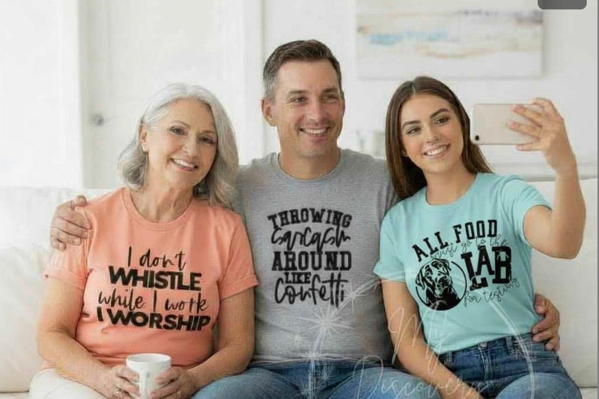 Three people sitting together wearing t-shirts with humorous text designs.